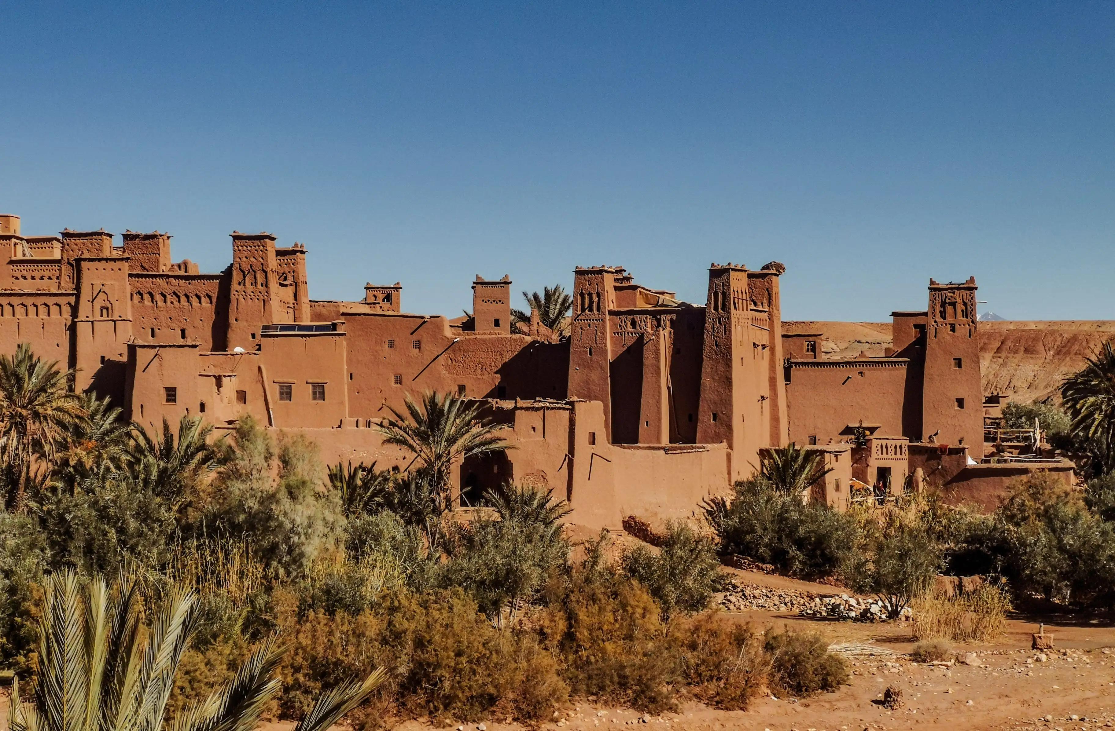 Kasbah historique en terre cuite et fortifications du ksar d'Aït-Ben-Haddou sous un ciel bleu