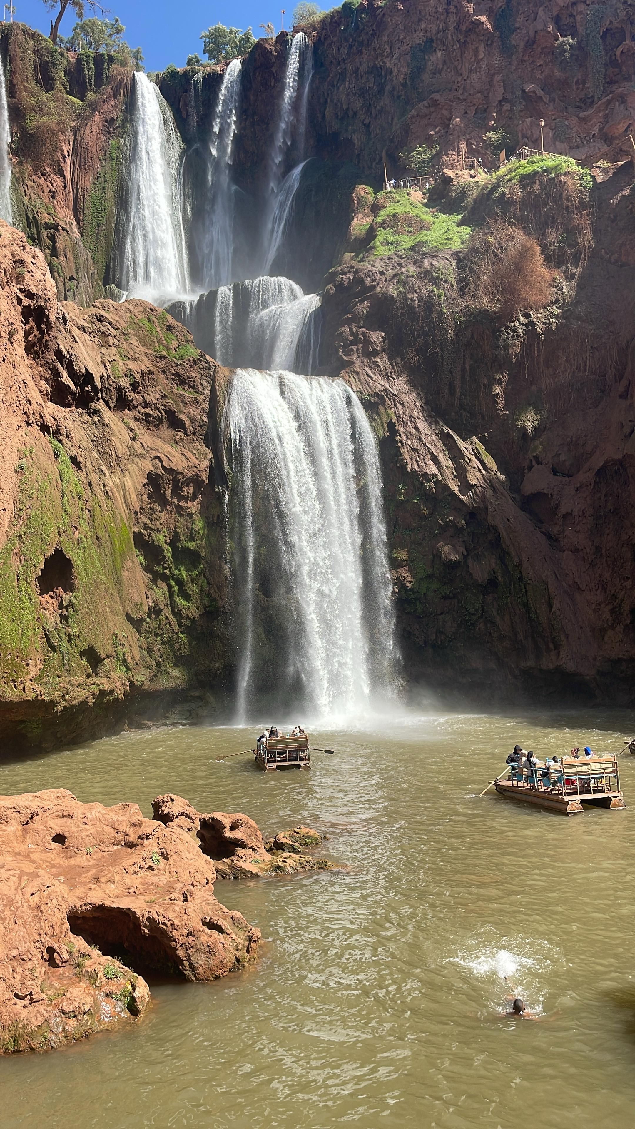 Cascades d'Ouzoud jaillissant dans un bassin naturel entouré de rochers et de verdure